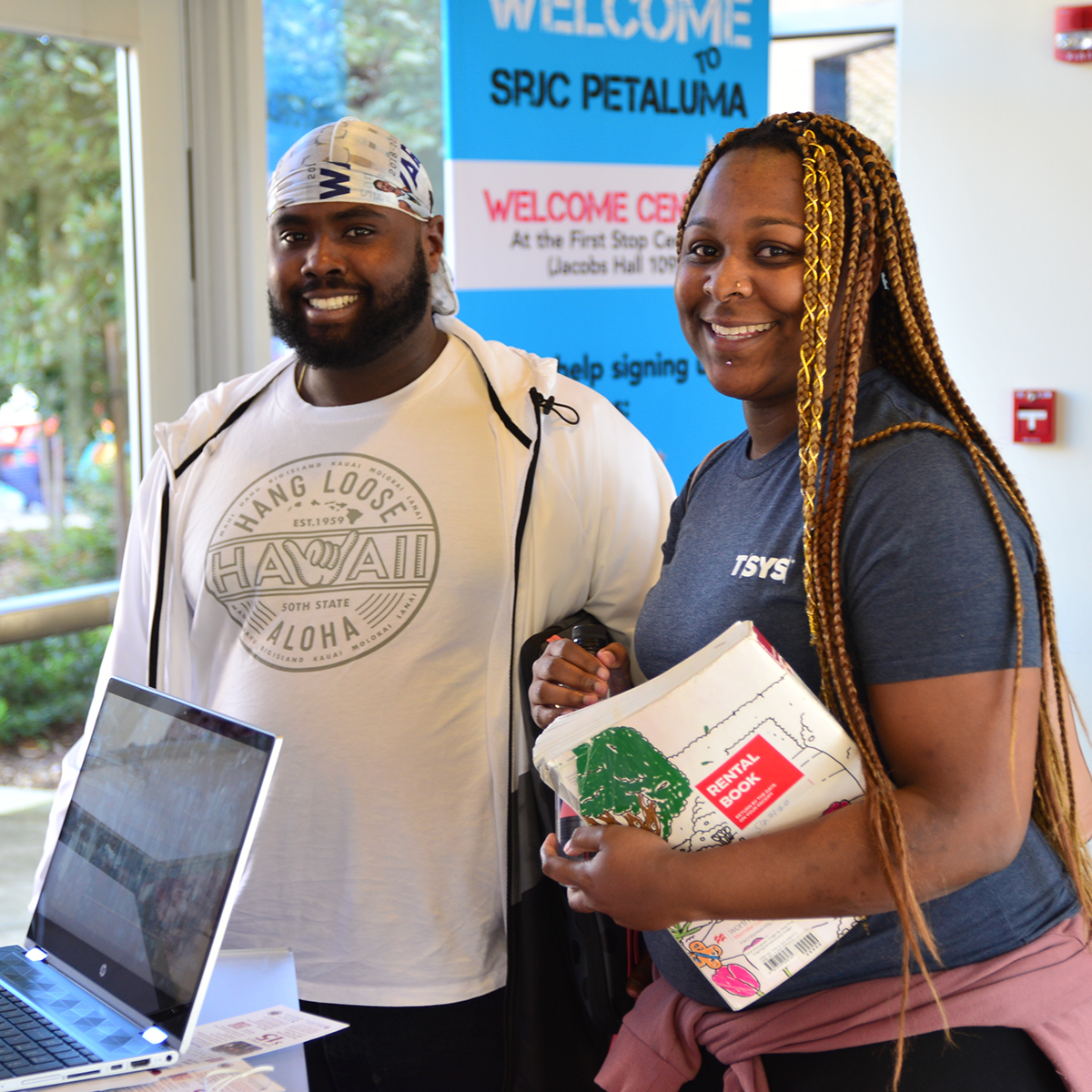 Two students in front of a sign that says welcome to srjc Petaluma